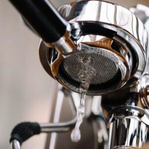 A close up of an espresso machine with the lid open.