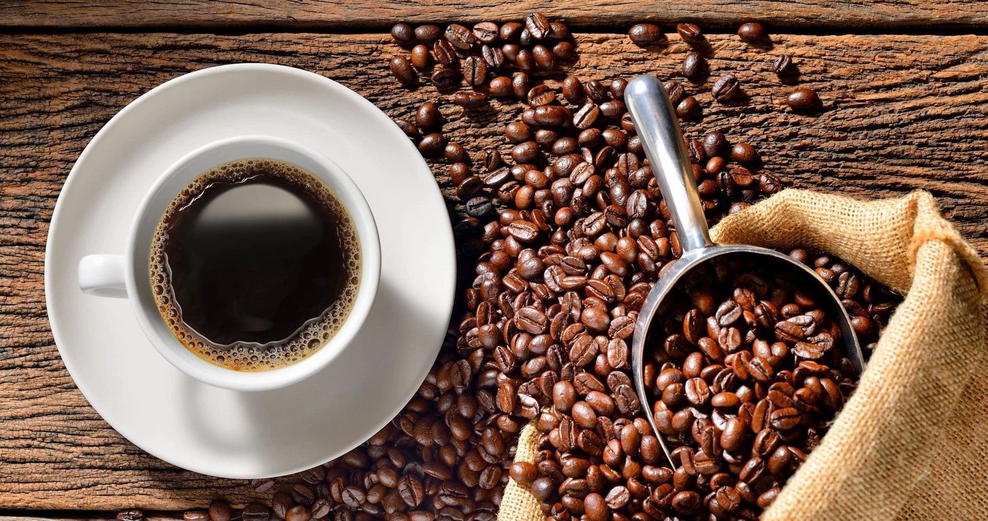 A cup of coffee sitting on top of some beans.